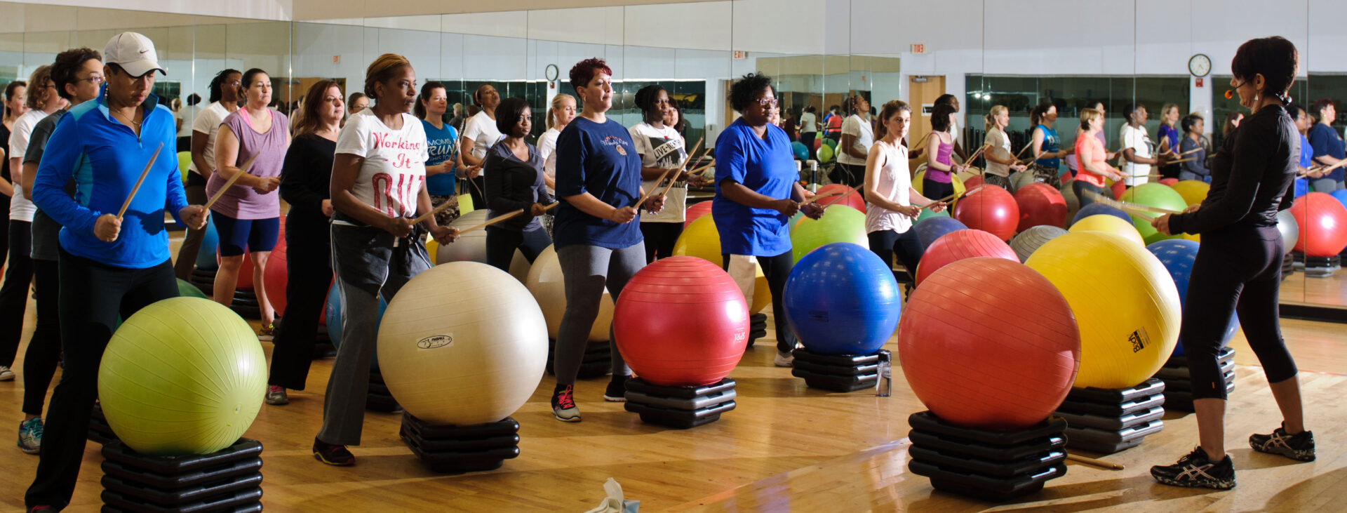 A group of people standing around some exercise balls