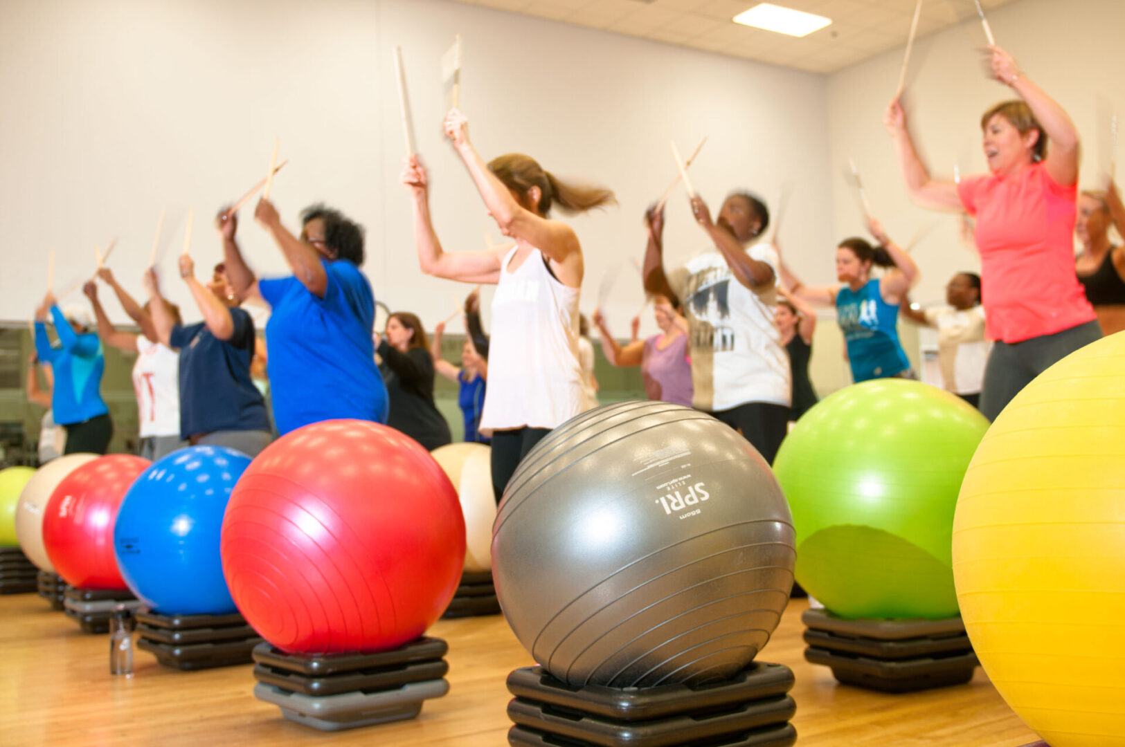 A group of people in a gym with exercise balls.